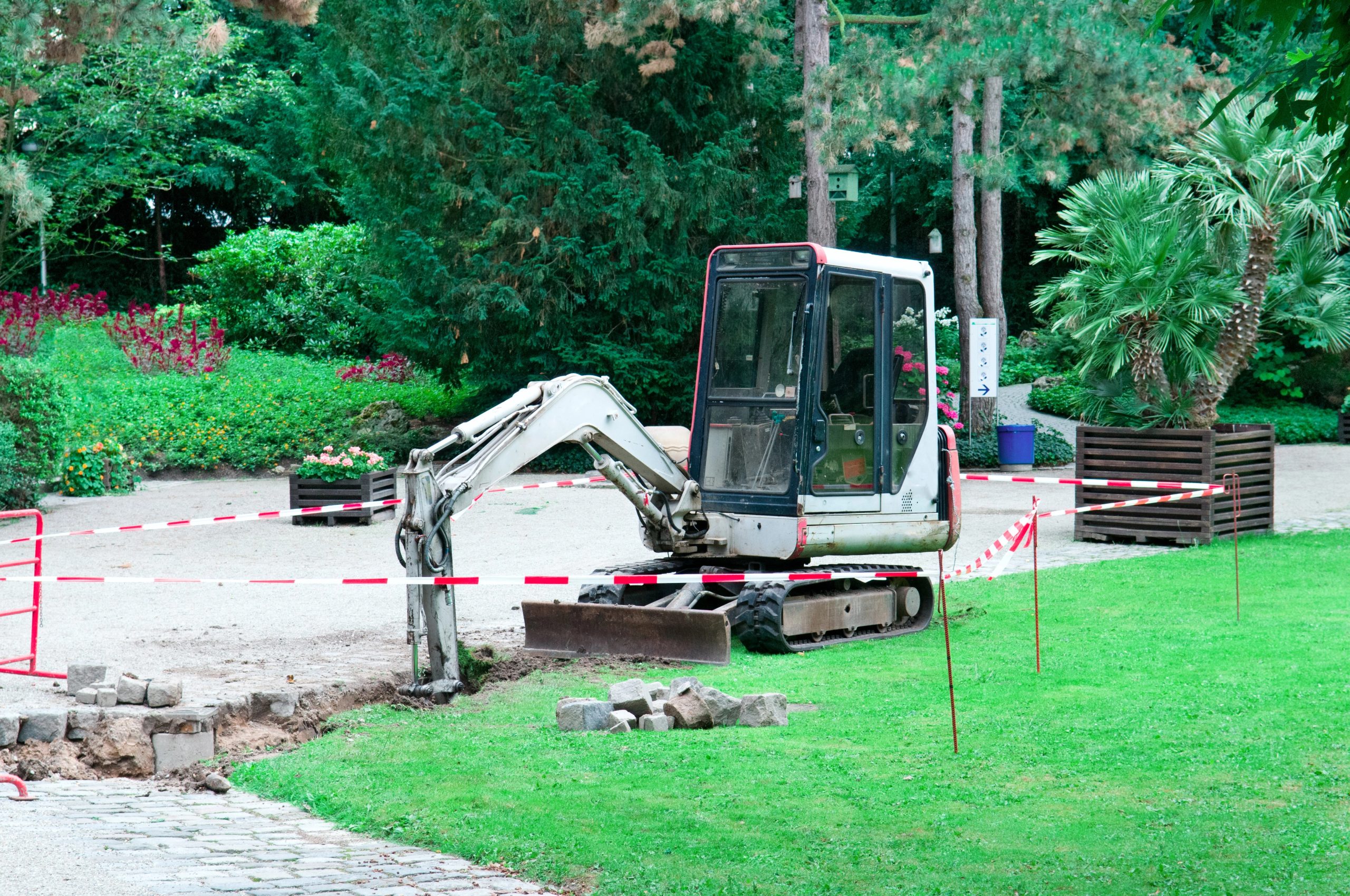 Excavator preparing a site beside established trees