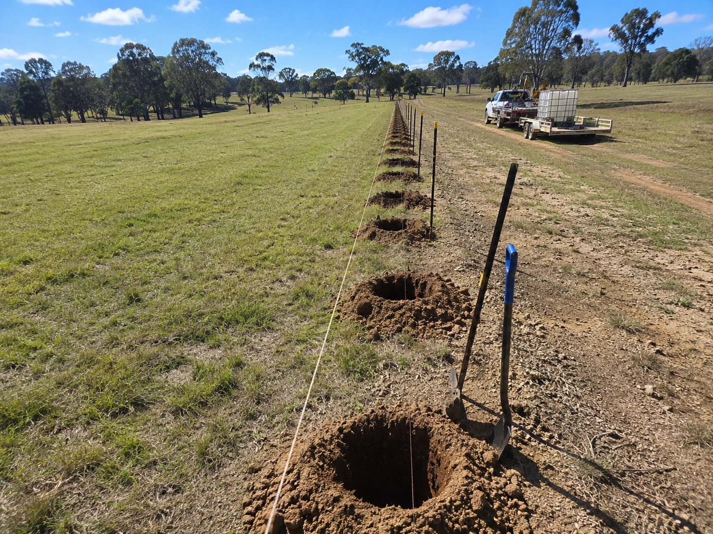Prepared rural fence post holes along a property line